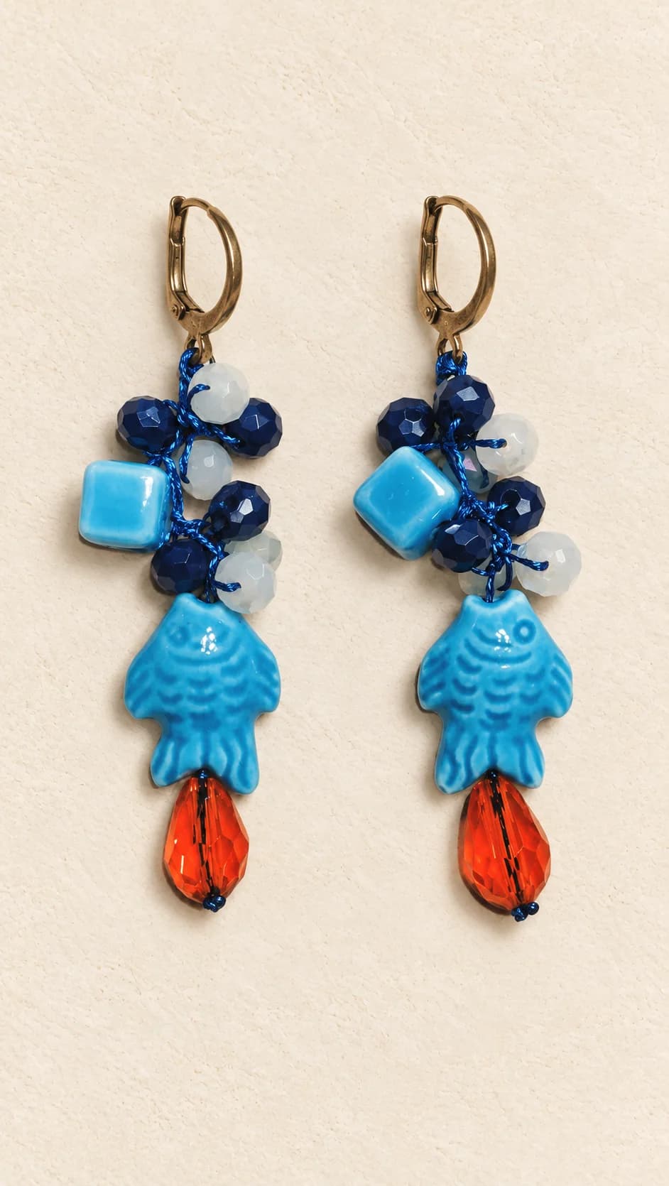 Coppia con elementi blu e turchesi, pendenti a pesce e gocce arancioni. Corallo nel nome indica il colore, non il materiale.