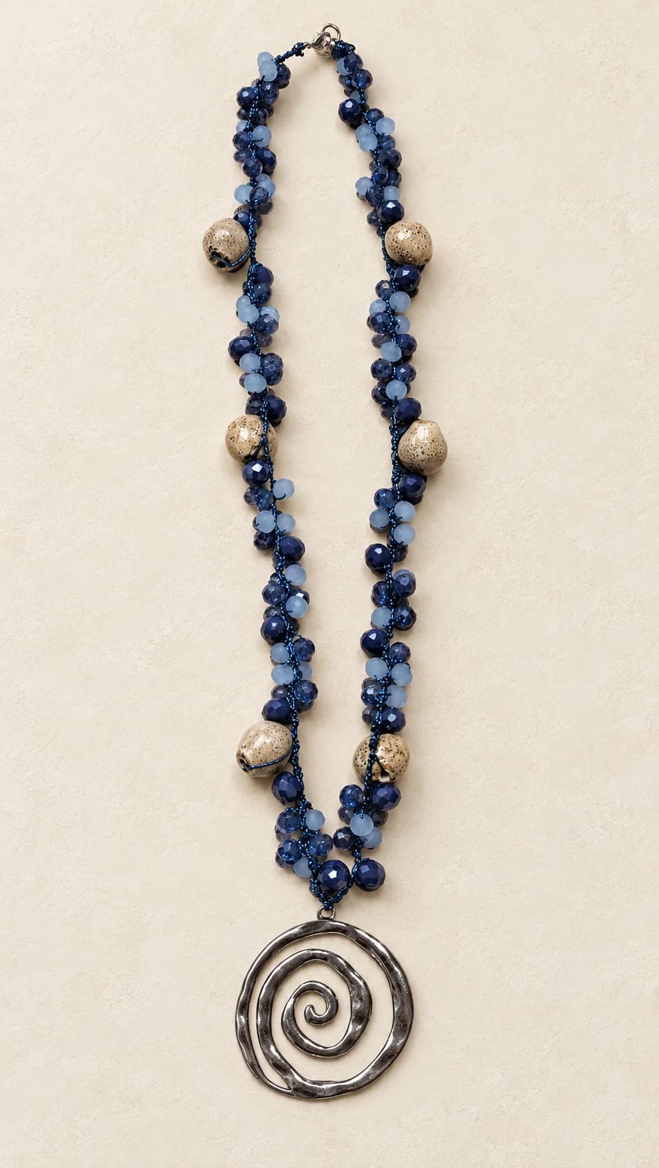 Elementi blu e chiari di forme diverse, collegamenti scuri e pendente circolare con disegno a spirale.