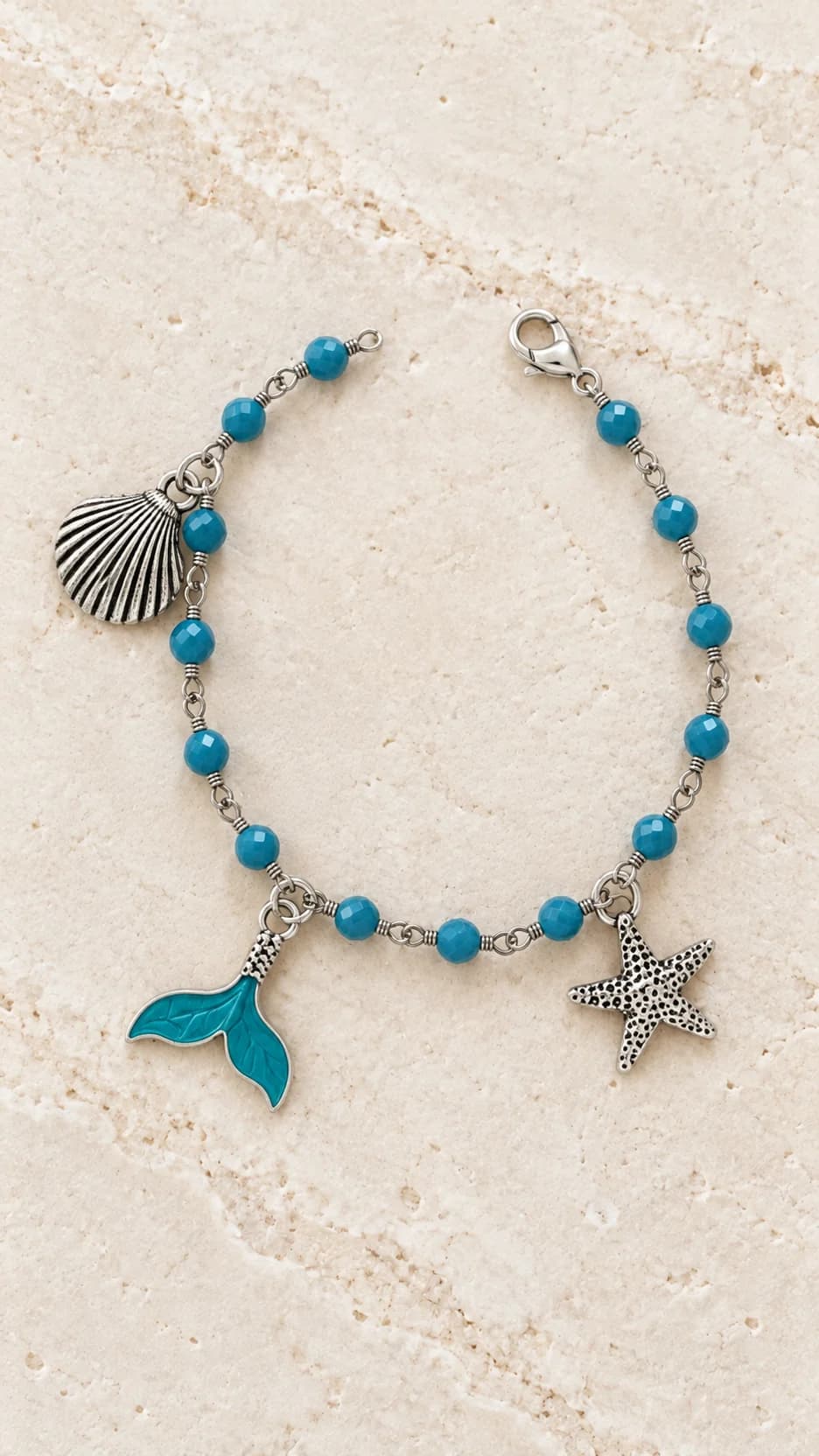 Bracciale con piccoli elementi turchesi, pendenti dal tono argentato a conchiglia e stella marina e coda turchese.