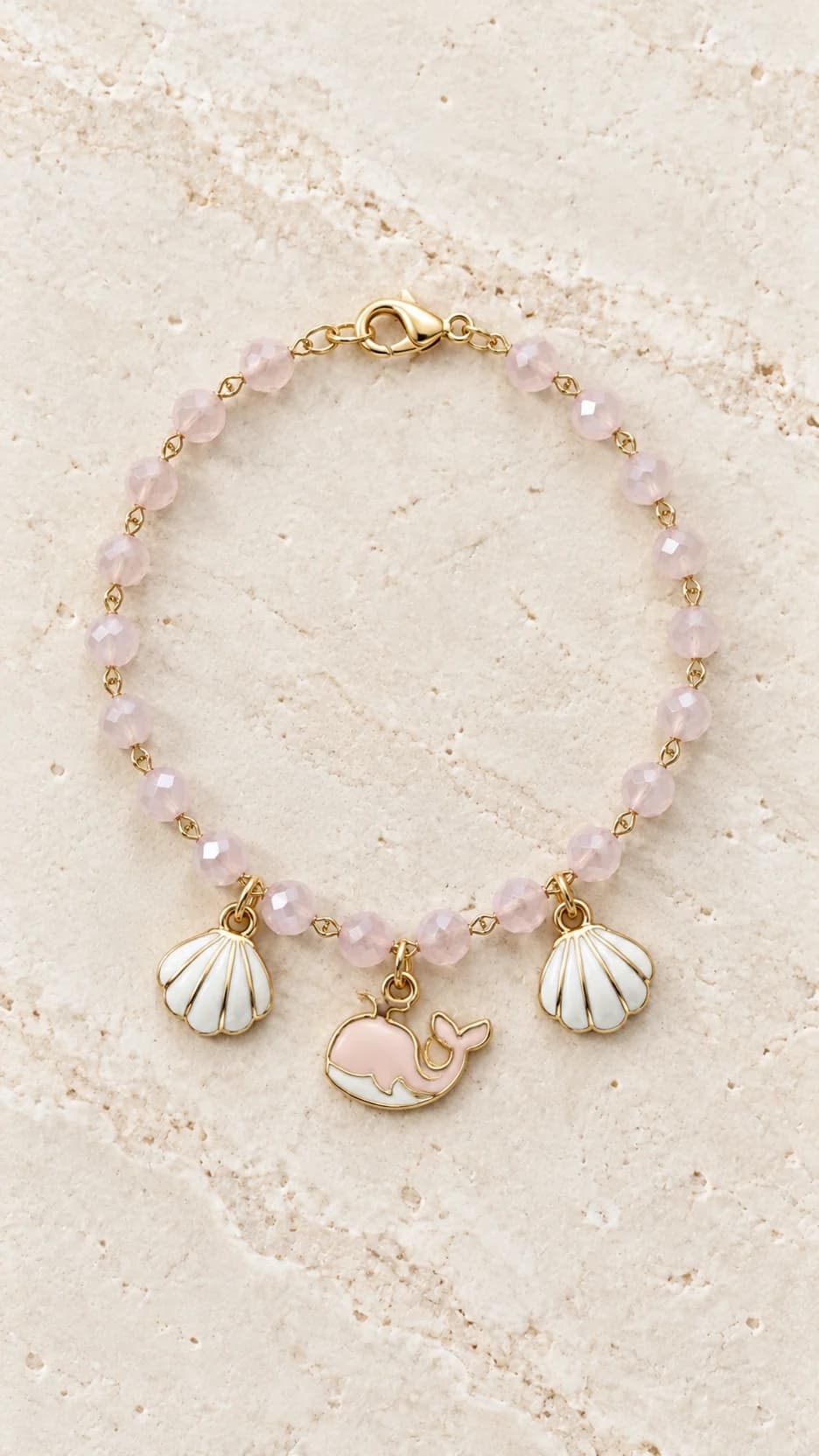 Bracciale con elementi rosa chiaro sfaccettati e pendenti bianchi e rosa a conchiglia e balena.
