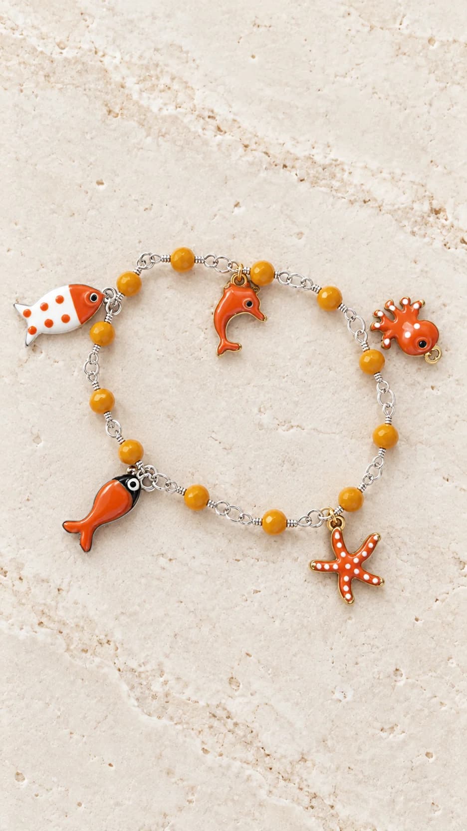 Bracciale con elementi arancio sfaccettati e pendenti marini arancio e bianchi su collegamenti dal tono argentato.