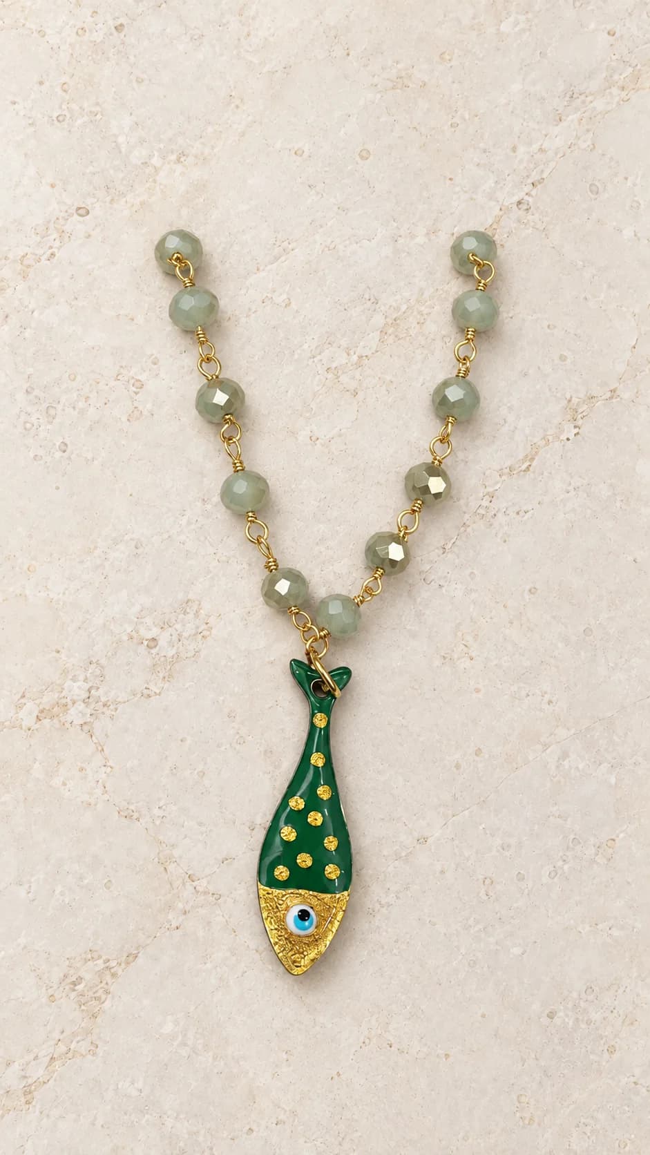 Collana con elementi salvia sfaccettati, collegamenti dal tono dorato e pendente verde a forma di pesce.